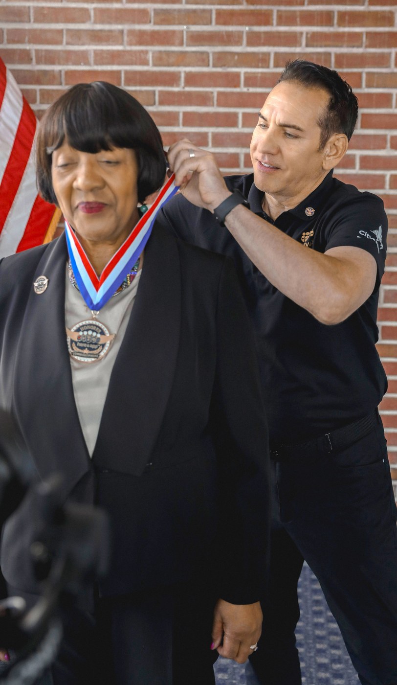 Jerome Mark Mikulich places the Honor Medal on Mary L. Aurtrey